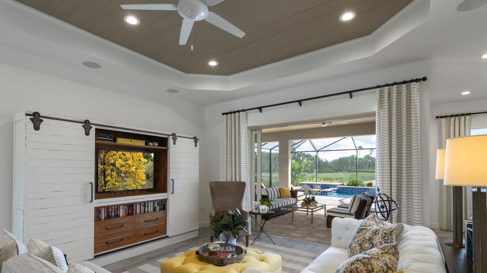 Existing model-home photograph of a great room opening onto a lanai